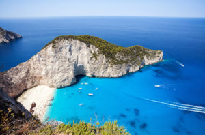 la famosa spiaggia di navagio in Grecia con molte barche in giro per la Grecia