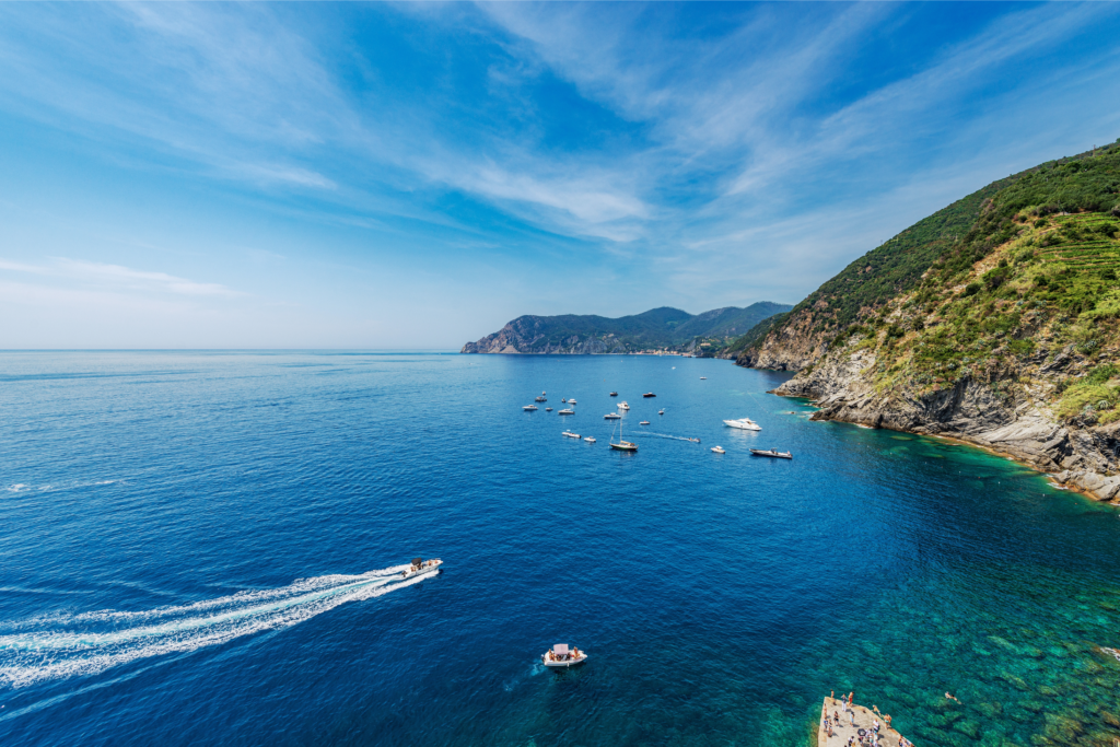 Vista panoramica di una baia circondata da scogliere con diverse imbarcazioni in navigazione